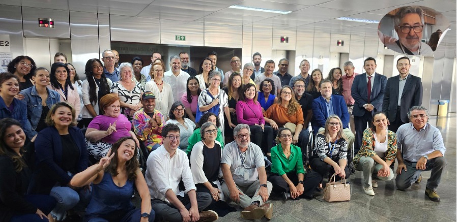 Foto com participantes do encontro, cerca de 80 pessoas, e Kal. Estão todos posando para a foto, alguns de pé e outros agachados à frente.